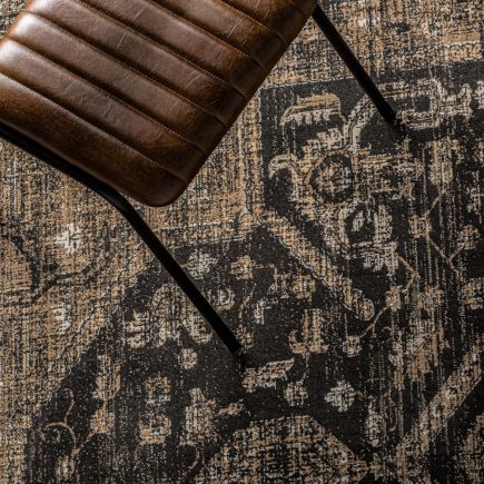 Alfombra Rectangular Marrón Vallee y silla de cuero sobre ella